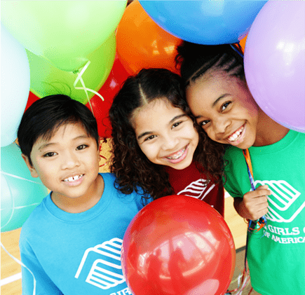 three young children holding balloons and smiling for the camera