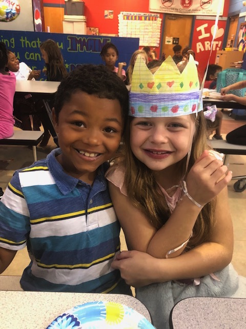 two children pose for a picture with a birthday cake
