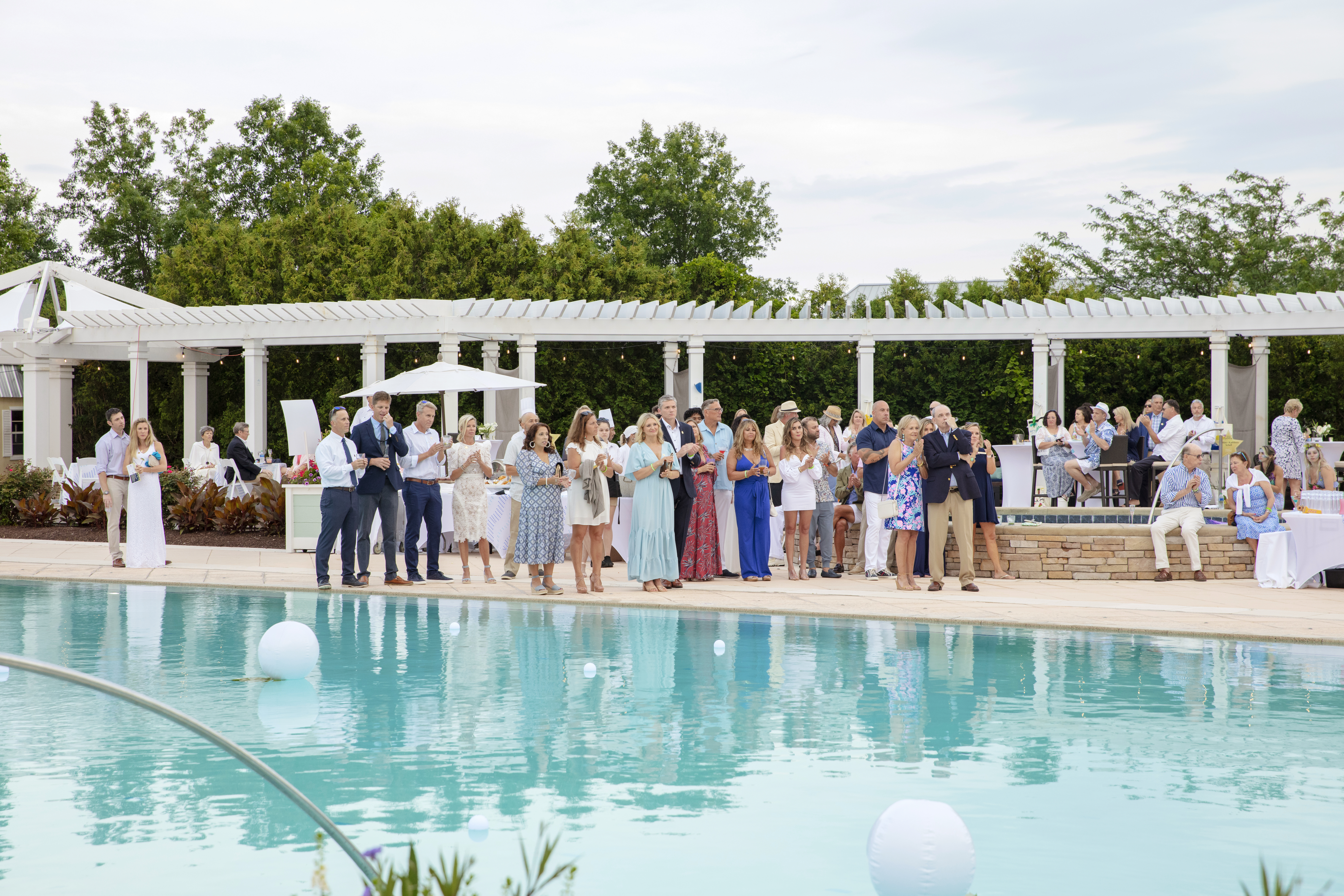 a group of people standing around a pool