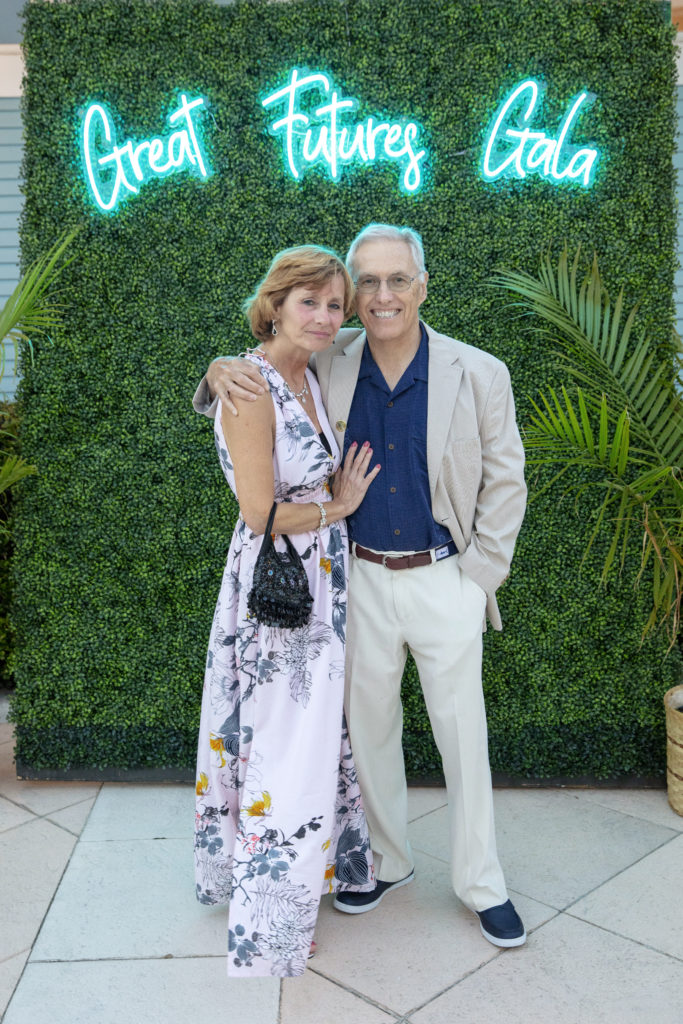 a man and woman standing in front of a green wall