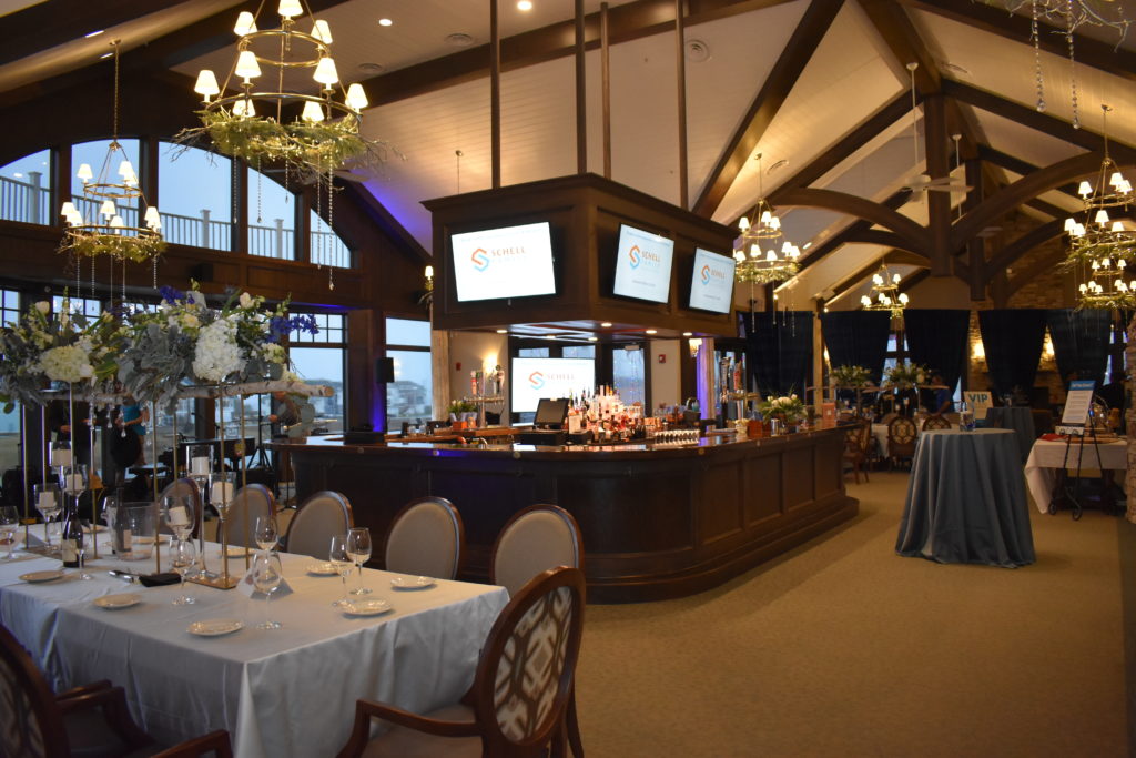 event room with large bar and chandeliers