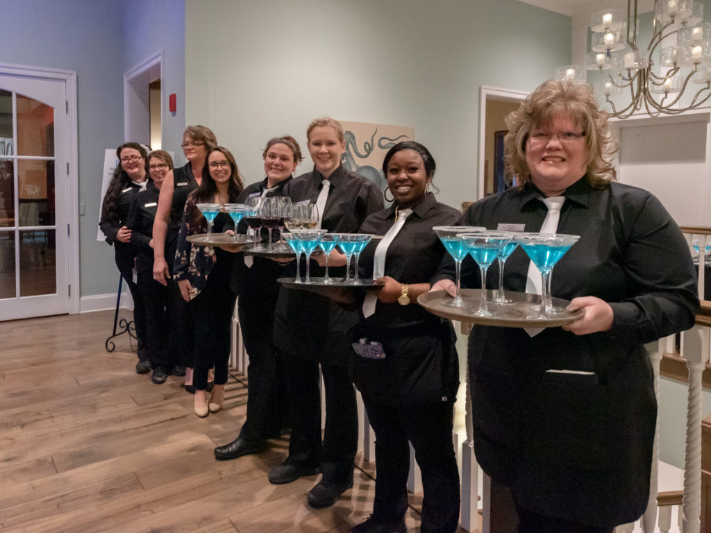servers holding trays of blue drinks at the great futures gala