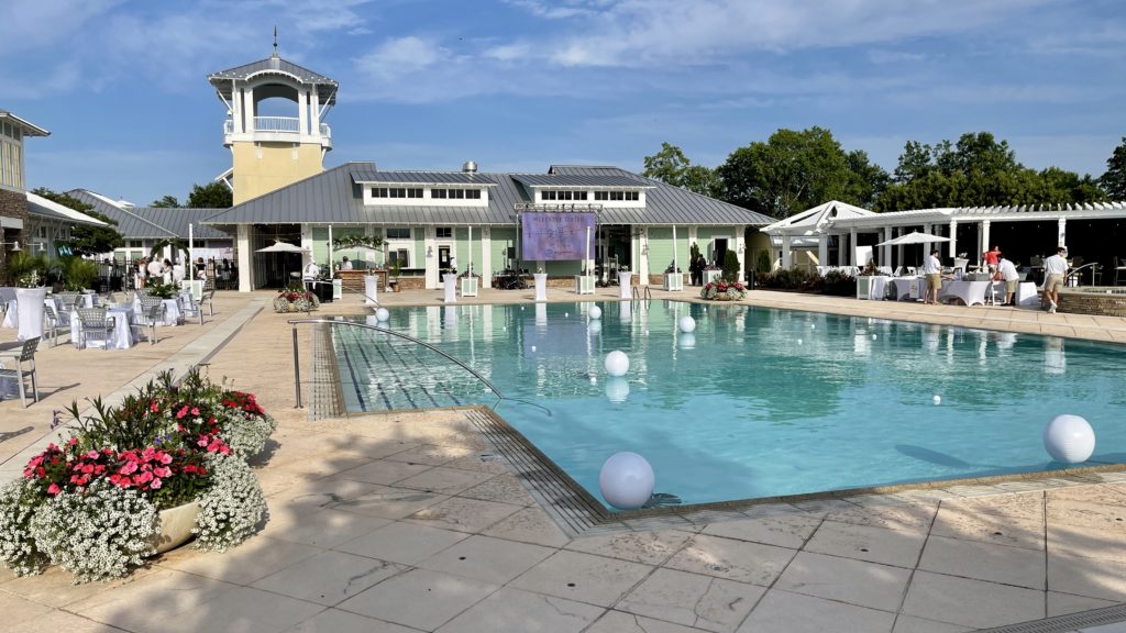 outdoor pool event with white tables and decorations